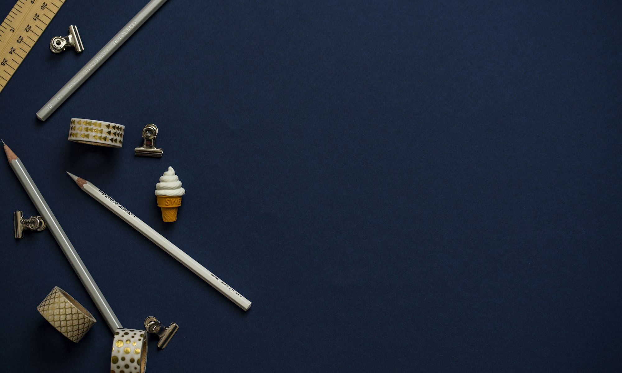 Stationery arranged on a deep navy surface